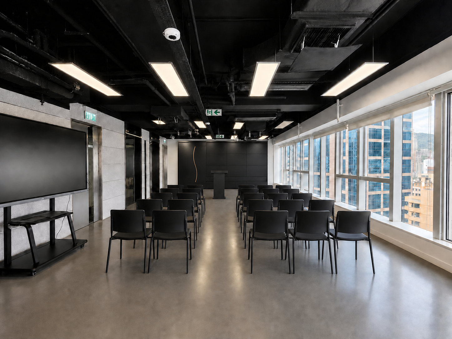 HUB 239 工作坊座位佈置示意,黑色椅子面向帶金銅弧線的九格媒體牆並保留中央通道